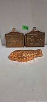 Front view of two copper plaques and fish mold