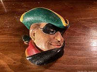 front view of chalkware head showing facial features, hat and mask