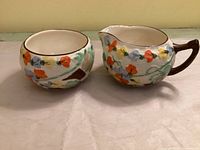 cream pitcher and sugar bowl front view showing pansy decorations