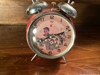 Front view of the alarm clock showing dial artwork, numerals and hands