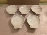 Five of six shell dishes front view showing shape and glaze