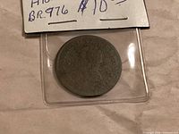 Token in protective flip showing obverse patina and wear