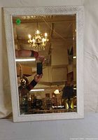 Front view of rectangular white framed mirror