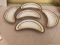 Overhead view of the five matching crescent bone dishes with floral and gold decoration