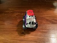 Front angled view showing silver cab with eyes, red roof detail, large tires