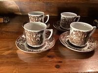 Four cups each on its saucer, brown transfer print visible