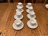 Eight cup-and-saucer sets arranged on table