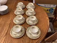 All eight cup-and-saucer pairs arranged on table