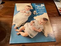 Front cover of Patons No.175 Baby Encore booklet showing two babies in knit garments