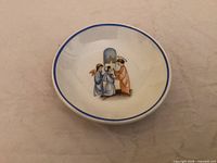 Top view showing blue-rimmed white dish with central religious motif