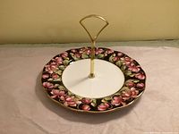 Top view showing floral pattern, gold handle, scalloped rim