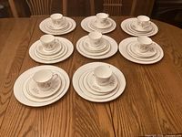 Eight 5-piece place settings displayed on table
