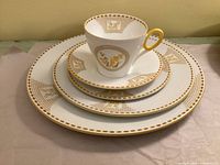 Stacked place setting showing teacup, saucer, bread, salad and dinner plates