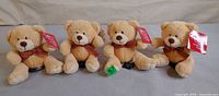 Group shot of four Russ Brady plush teddy bears standing side by side