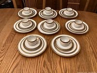 Eight complete place settings arranged on table