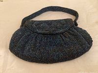 Front view of beaded evening purse showing flap and gathered body