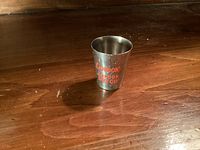 Metal shot glass with Gordon’s London Dry Gin red lettering