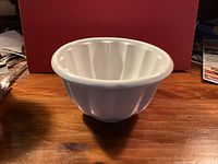 Side view of white fluted ceramic jelly mould