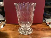 Front view of clear pressed glass vase on footed base