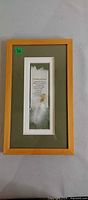 Front view of framed wall art with poem and feather detail