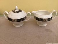 Cream pitcher and lidded sugar bowl front view