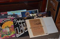 Group shot of all visible vinyl albums standing against cabinet