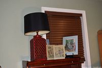 Lamp atop furniture with two matted prints visible