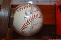 Close-up of autographed baseball in clear case