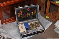 Open case showing tools in lid and adapters in base