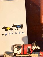Cow Parade box front with silhouetted cow logos and partial view of Under Construction cow