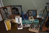overview of lot showing framed photos, magazines, Presley Blvd sign, music box, books