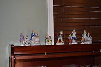 All eight figurines lined on shelf for group view