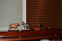 Wide shot showing all four figurines on shelf