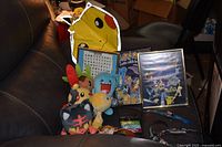 Group shot showing plush toys, bag, framed pictures and accessories on couch