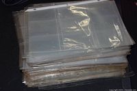 Stack of clear nine-pocket binder pages shown from top left