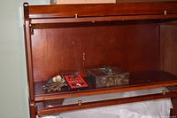 Cluster of silverplate spoons, cloisonné spoon case, partial view of rack area