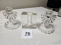 Front view of two crystal candle holders and rectangular glass vase