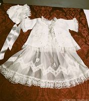 Full view of dress, jacket and bonnet laid out