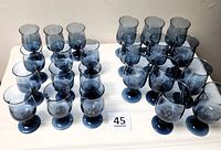 All 23 blue-tinted Pfaltzgraff glasses arranged on table