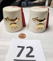 Front view of both shakers with emblem and penny for scale