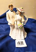 Front view of porcelain bride and groom figurine on blue fabric