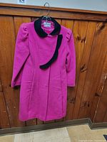 Full view of magenta child’s coat on hanger