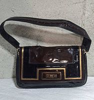 Front view of black patent leather Anya Hindmarch for Target shoulder bag with geometric panel and gold trim