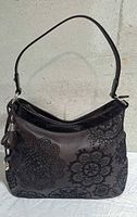 Front view of Brighton brown leather shoulder bag showing floral embossing and heart charm