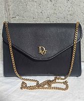 Front view showing flap, CD monogram, and gold chain