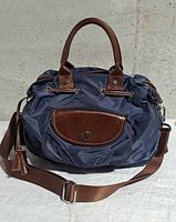 Front view showing nylon body, leather trim, top handles, shoulder strap, front pocket