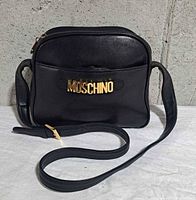 Front view showing MOSCHINO gold letter logo, overall shape and leather condition