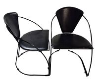 Perspective view showing both black faux leather dining chairs and metal frames