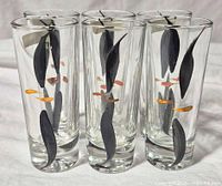 Six clear shot glasses with black and gold motif front view