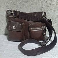Front view showing pockets, strap and leather texture